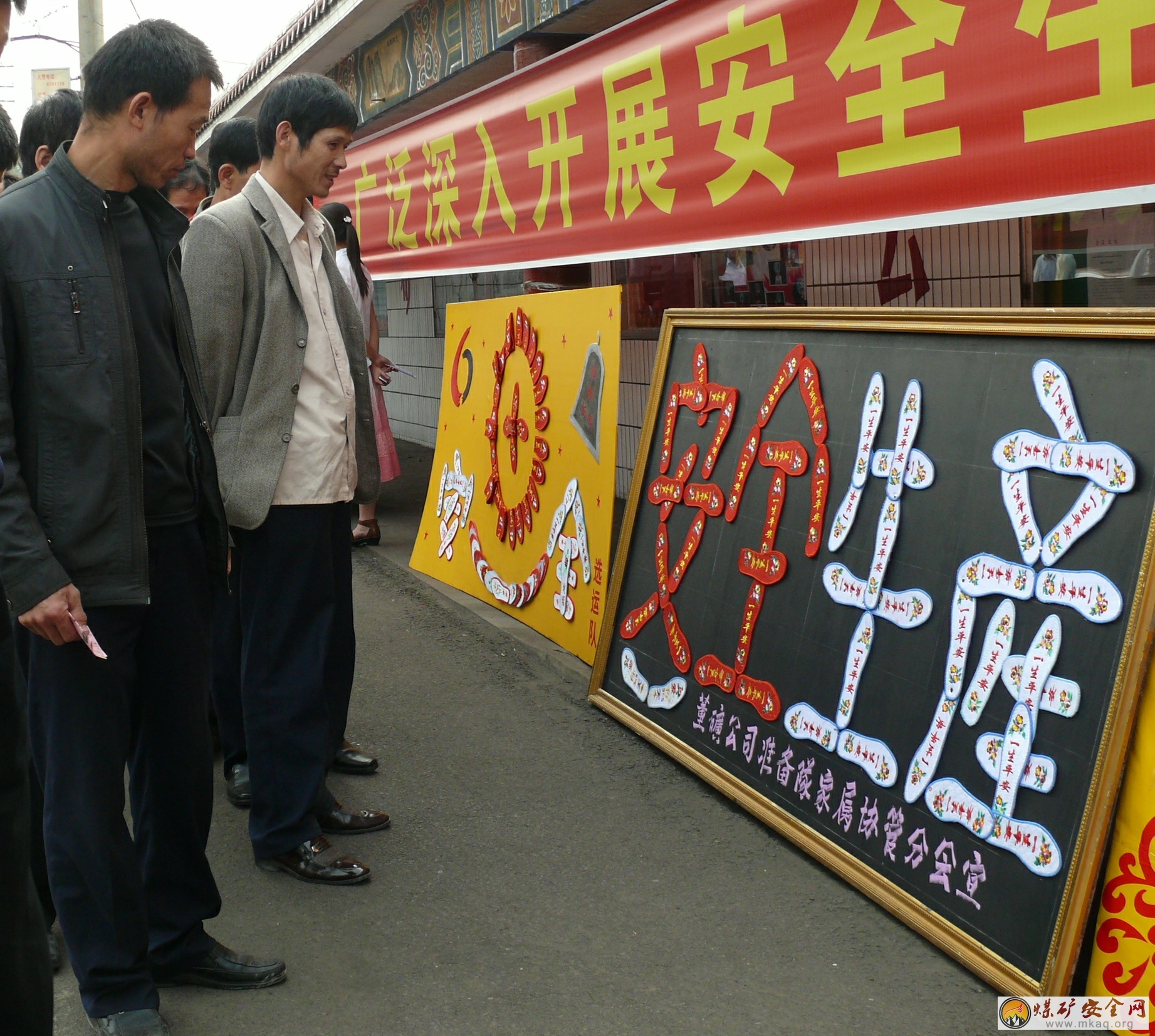 ?在安全生產(chǎn)月活動中，董礦分公司開展了安全牌板展活動，圖為干部職工觀看安全牌板時的情景